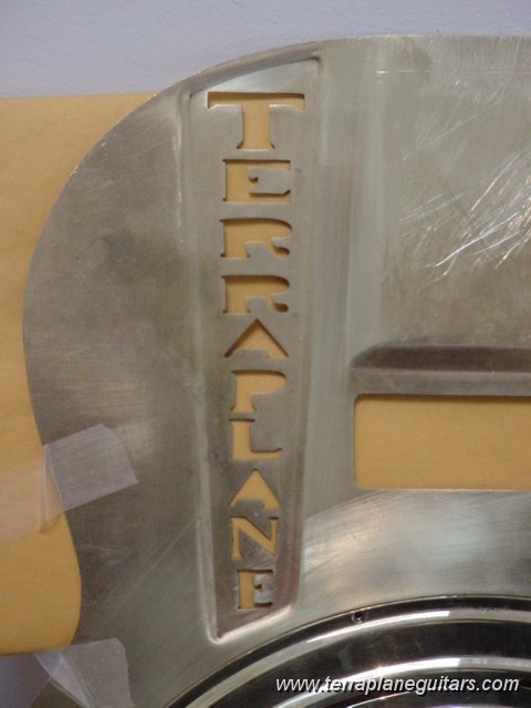 dsc00287.jpg - The TERRAPLANE top logo/soundhole is hand cut with the decorative surrounding indentation hand hammered. The soundhole font on the guitar matches the hubcap font of Arlen Roth's 1930's Hudson Terraplane.